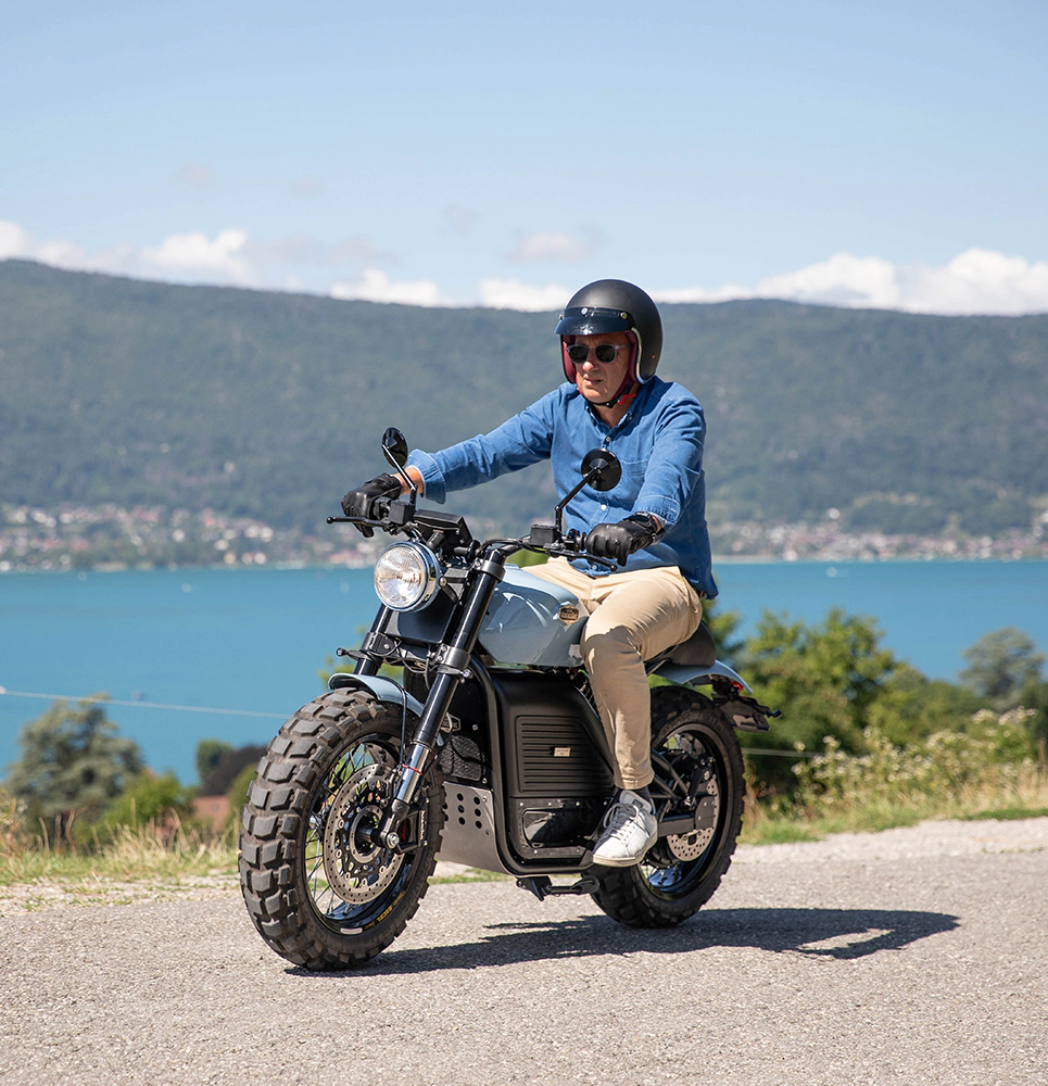photo en mouvement de la moto électrique Heritage Spirit Scrambler sur les hauteurs du lac d’Annecy à Menthon-Saint-Bernard